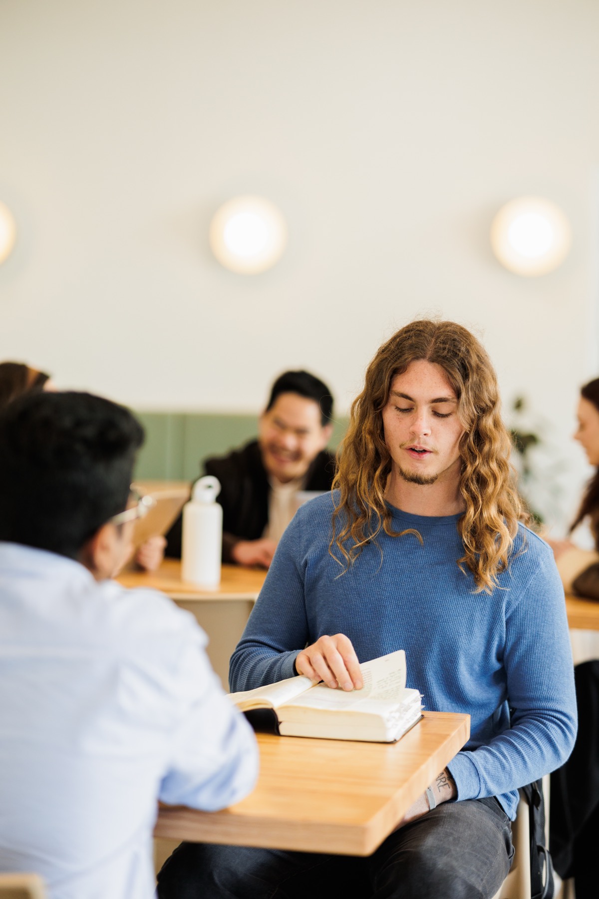 A student reading alone in the college common room